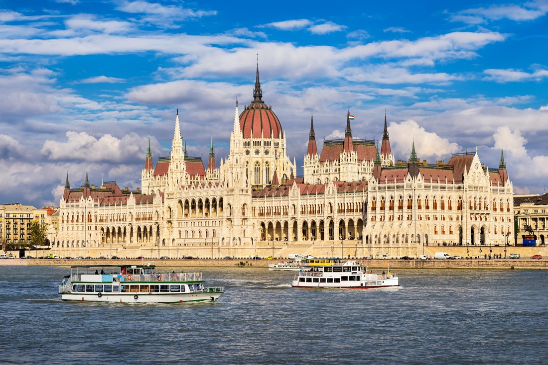 Small ships cruising next to Parliament building in Budapest, Hungary